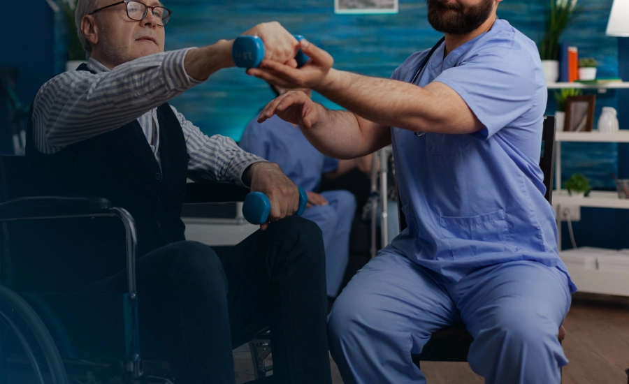 A nurse assists a man in a wheelchair during a physiotherapy session, highlighting support and care in rehabilitation home visit physiotherapist Birmingham